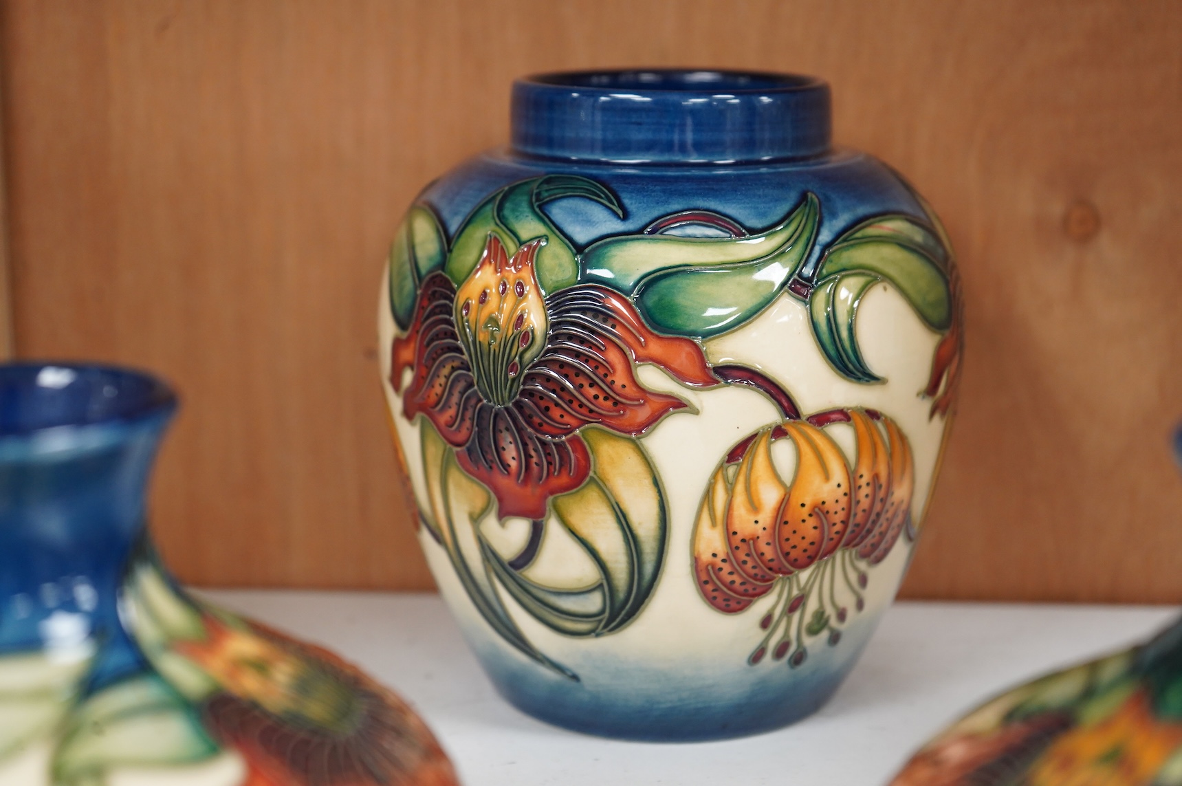 Two modern Moorcroft vases and a jar in the Anna Lily pattern, largest 14cm high